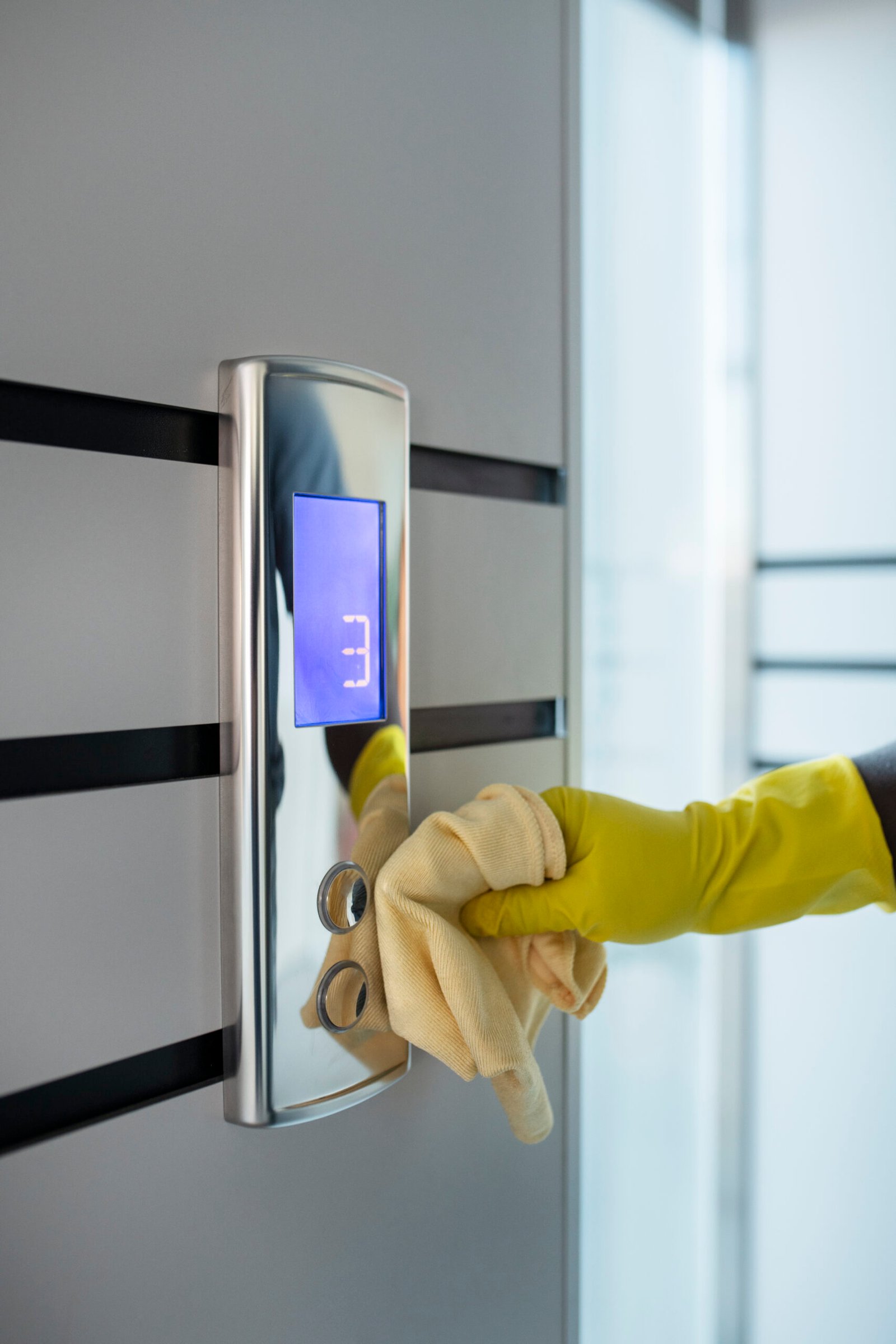 hand-cleaning-elevator-buttons-with-cloth